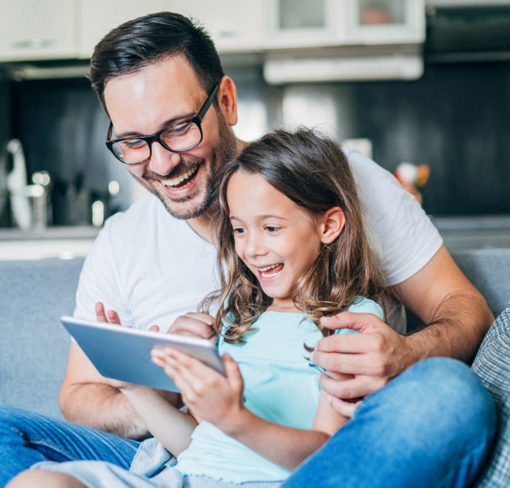 Padre e hija riéndose de la tableta