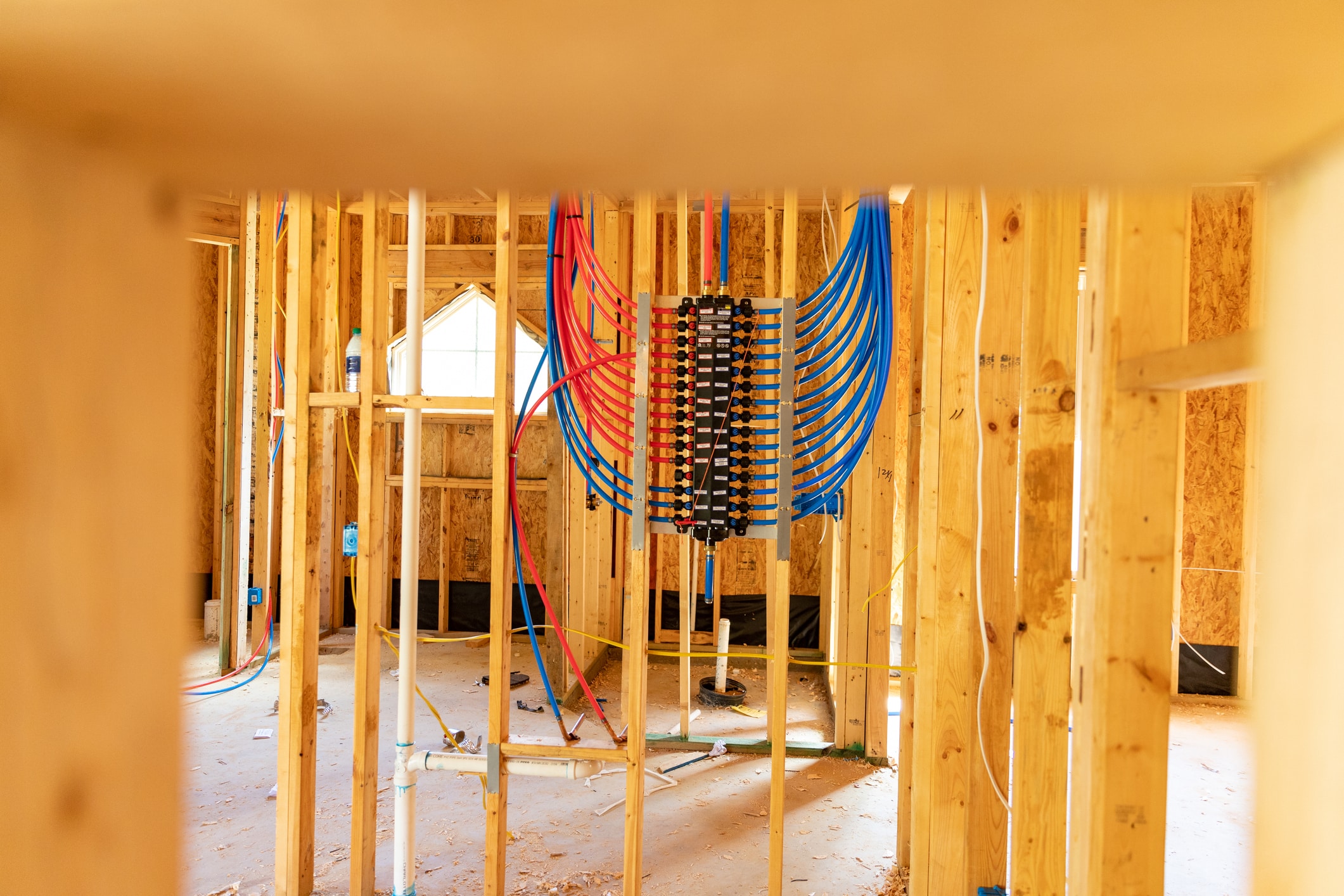 PEX plumbing manifold for water distribution in new home construction\. Selective focus